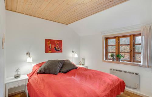 a bedroom with a red bed and a window at 2 Bedroom Lovely Home In Højslev in Højslev