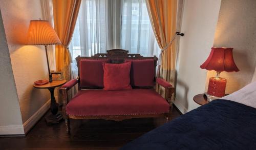 a bedroom with a red chair and a bed at The 1890 Freeman House in Galveston
