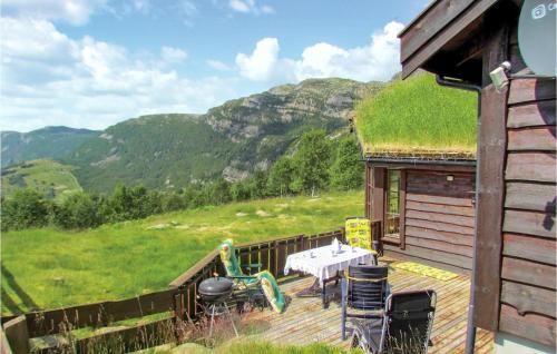 a house with a grass roof with a table on a deck at Holiday Home Vikeså Stavtjørn Iii in Hovland