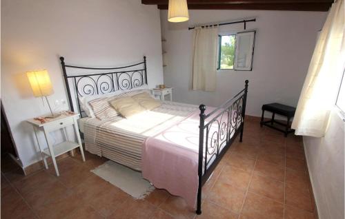 a bedroom with a bed and a table and a window at 2 Bedroom Gorgeous Home In Algaida in Algaida