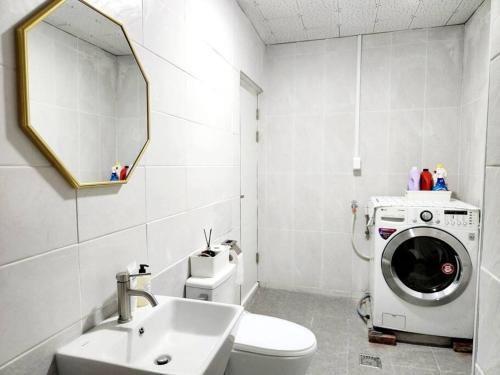 a bathroom with a washing machine and a sink at Breathe Hanok Village Nambu Market in Jeonju