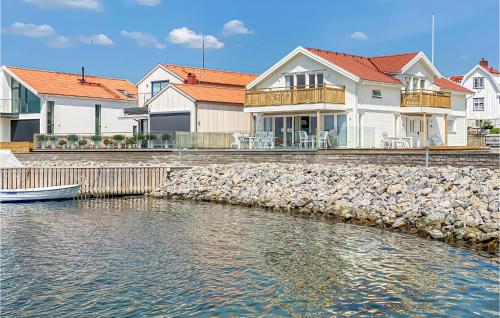 a group of houses by the water with a boat at Cozy Apartment In Rönnäng With Kitchen in Rönnäng