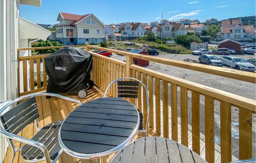 a table and chairs on a balcony with a view of a parking lot at Cozy Apartment In Rönnäng With Kitchen in Rönnäng