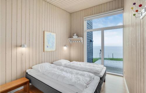a bedroom with a large bed and a large window at Holiday Home Roslev With A Fireplace 01 in Øster Lyby