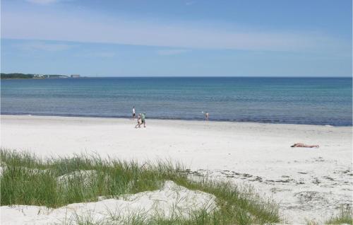 a group of people walking on the beach at Holiday Home Tørveskæret Nexø Xii in Snogebæk