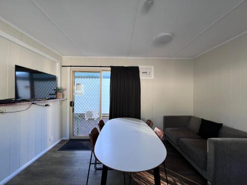 a living room with a couch and a table at Strahan Beach Tourist Park in Strahan