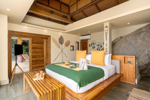 a bedroom with a large bed and a table at Wild Cottages Luxury and Natural - SHA Extra Plus Certified in Lamai
