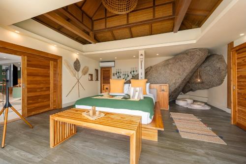 a bedroom with a bed and a large rock at Wild Cottages Luxury and Natural - SHA Extra Plus Certified in Lamai