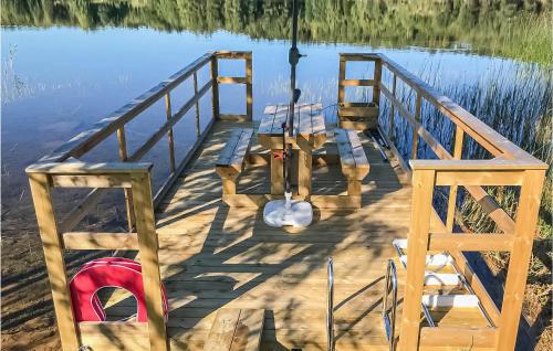 a dock on the water with a red life preserver at Gorgeous Home In Svanskog With Wifi in Svanskog