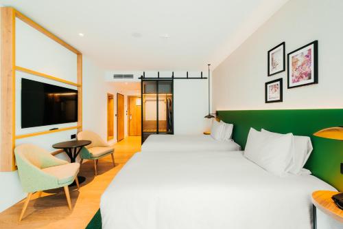 a hotel room with two beds and a tv at Hilton Garden Inn Radom in Radom