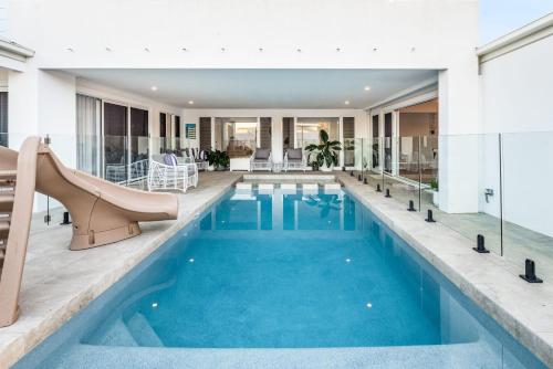 an indoor pool with a slide in a building at Golden Beach Ultimate Family Getaway - Pool & Spa in Golden Beach