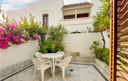 a patio with a table and chairs and flowers at Beautiful Apartment In Estepona in Estepona