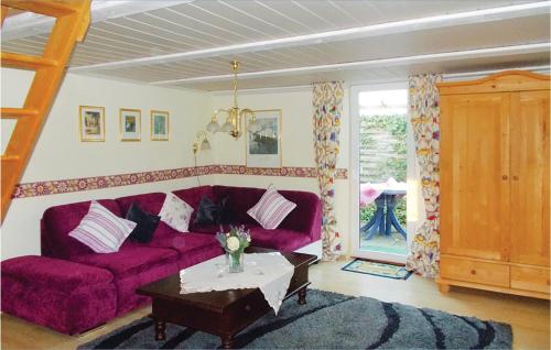 a living room with a purple couch and a table at Holiday Home Waldreihe Q in Saal
