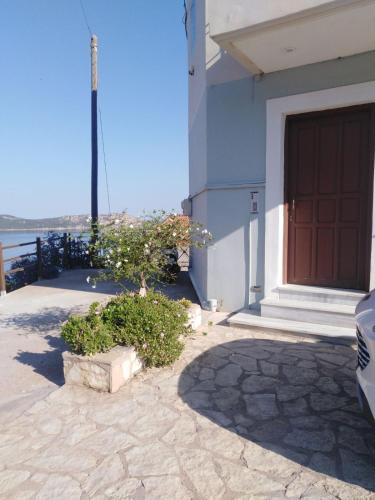 a building with a door and a tree in front of it at Bay blue in Pylos