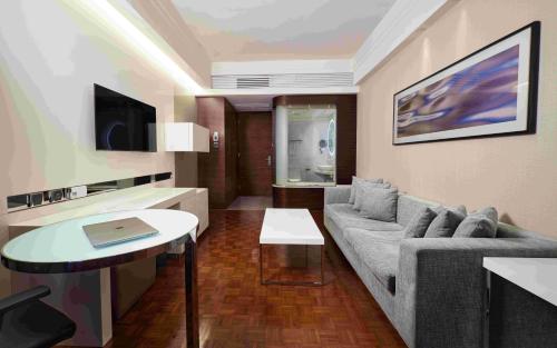 a living room with a couch and a table at Nina Hotel Island South in Hong Kong