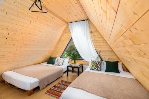 VenoSea Tsikhisdziri Seaside Cottage في تسيكهيسدزيري: سريرين في غرفة علوية مع نافذة