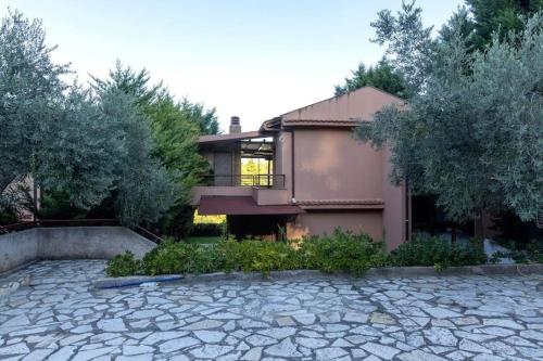 ein Haus mit einer steinernen Einfahrt davor in der Unterkunft Sani Pinecone Villa 3 in Sani Beach