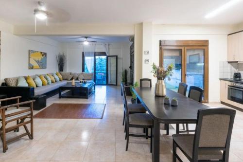 ein Esszimmer und ein Wohnzimmer mit einem Tisch und einem Sofa in der Unterkunft Sani Pinecone Villa 3 in Sani Beach
