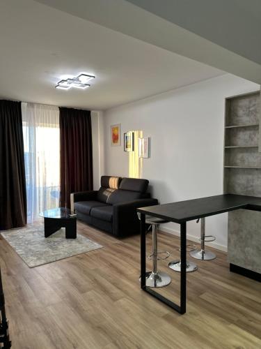 a living room with a black couch and a table at Zenit Apartment Oradea in Oradea
