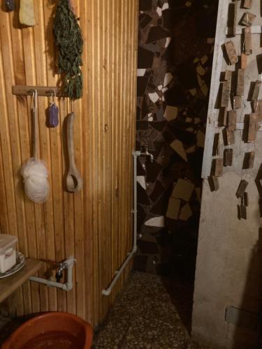 a bathroom with a wooden wall with a toilet in it at PIE OPĪŠA in Cēsis