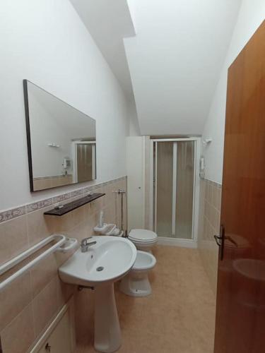 a bathroom with two toilets and a sink and a mirror at Casa Vacanza Nenè in Partanna