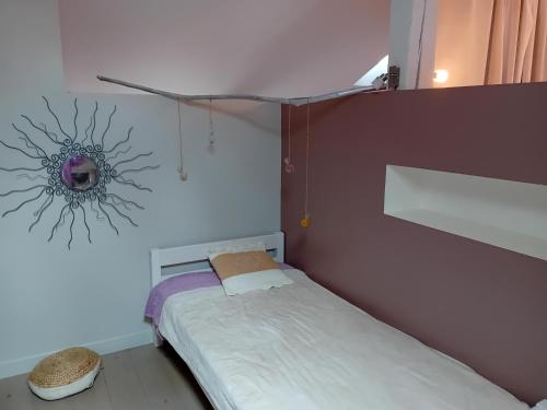 une petite chambre avec un lit et un miroir dans l'établissement Charmante maison de ville proche rivière, à Saint-Maixent-lʼÉcole