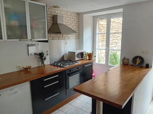 - une cuisine avec un comptoir et une cuisinière four supérieur dans l'établissement Charmante maison de ville proche rivière, à Saint-Maixent-lʼÉcole