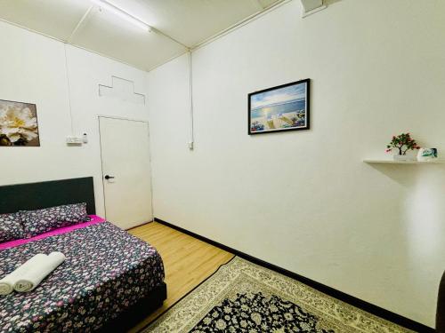 a bedroom with a bed and a picture on the wall at Wawa Homestay Bandar Jeli in Jeli