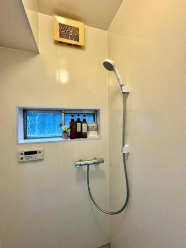 a shower in a bathroom with a window at 和居 霊羽 日本の伝統を感じる趣ある邸宅 in Osaka
