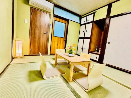 a living room with a wooden table and chairs at 和居 霊羽 日本の伝統を感じる趣ある邸宅 in Osaka