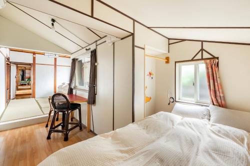 a bedroom with a bed and a desk and a chair at Entire House Popotel One in Matsumoto