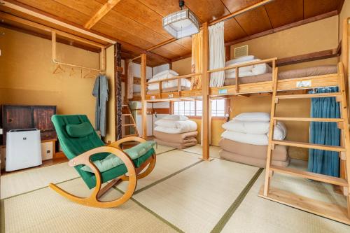 a room with bunk beds and a green chair at Entire House Popotel One in Matsumoto