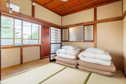 a room with two stacks of pillows on a rug at Entire House Popotel One in Matsumoto