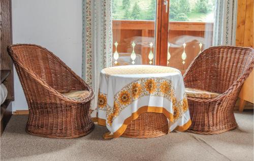 two wicker chairs with a table with a table cloth on it at Ferienhaus Mit Eigener Sauna in Hüttschlag