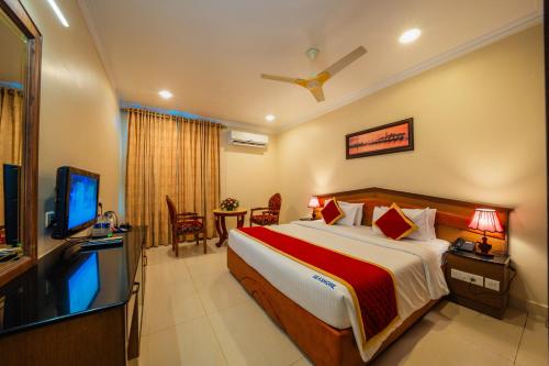 a bedroom with a bed and a flat screen tv at THE SEASHORE HOTEL in Kanyakumari