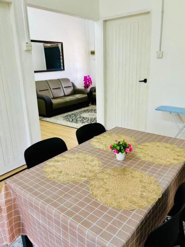 a table in a living room with a table cloth at Wawa Homestay Bandar Jeli in Jeli