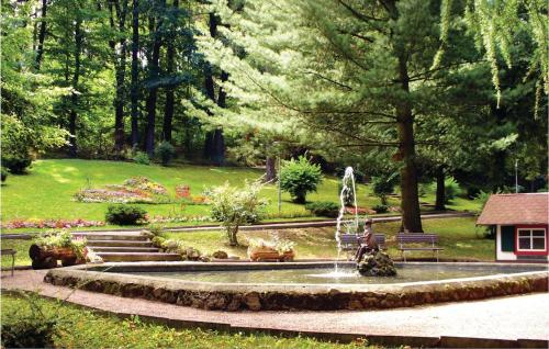 a fountain in a park with a person sitting on a bench at Pet Friendly Apartment in Waltershausen