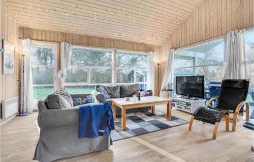 a living room with a couch and a table at Holiday Home Sandleddet Højby Ii in Lumsås