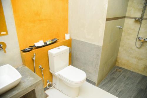 a bathroom with a toilet and a sink and a shower at Royal Tusker Hotel in Udawalawe