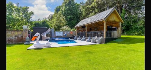 a backyard with a gazebo and a pool at Luxurious oasis relax 32c pool, jacuzzi games bar in Deal