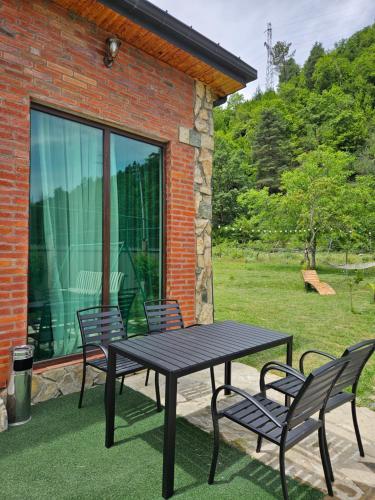 a picnic table and two chairs on a patio at WoodStar in Ambrolauri
