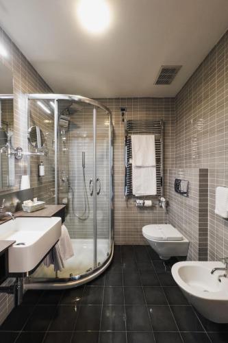 a bathroom with a shower and a sink and a toilet at Hotel Bel Sit in Meina