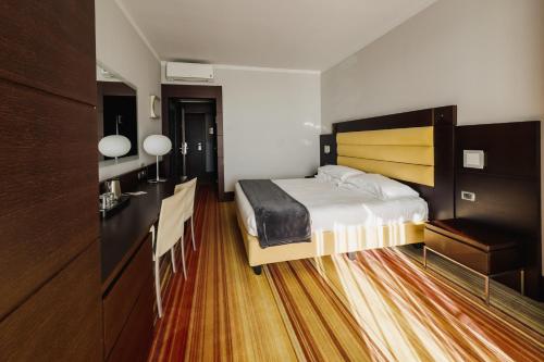 a bedroom with a bed and a desk and a sink at Hotel Bel Sit in Meina