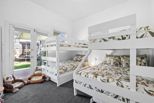 a bedroom with two bunk beds and a window at Charming Heritage Haven 'Ye Olde St Leonards Hotel' 3 Bedroom, Pet Friendly, Fire Place, Free Wifi & Netflix, Walk to Beach & Shops in Saint Leonards