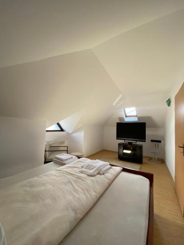 a white bedroom with a bed and a tv at MAT & EDW RooM in Câmpulung Moldovenesc