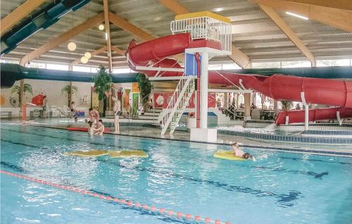 a group of people in a swimming pool with a water slide at Cozy Home In Vlagtwedde With Sauna in Vlagtwedde