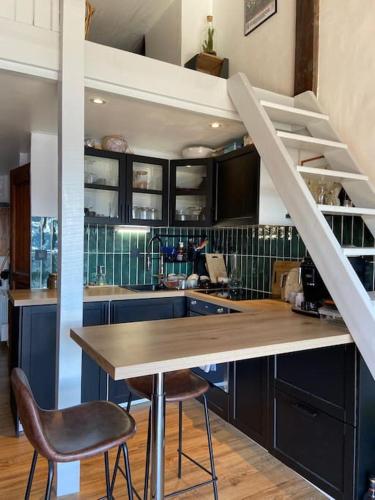 une cuisine avec une table et des chaises ainsi qu'un escalier dans l'établissement Emplacement exceptionnel- le Maona - Alpe D'huez, à Huez
