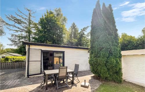 a tiny house with a table and chairs in a yard at Stunning Stacaravan In Putten in Putten