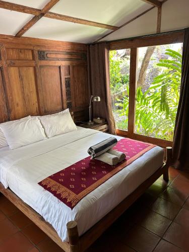 a bedroom with a large bed with a window at Villa Bhuvana with private swimming pool in Gili Trawangan