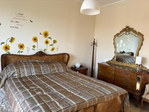 a bedroom with a bed and a mirror on the wall at Casa Gilot in Antignano